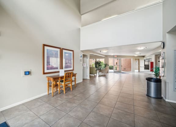 a corridor with a table and chairs in a hotel lobby