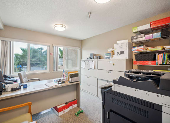 a home office with a desk and a printer