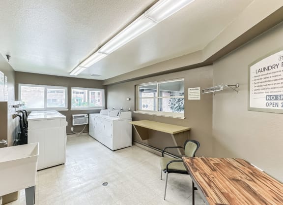 an office with a desk and a sink and a washing machine
