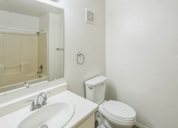 a bathroom with a sink toilet and a mirror