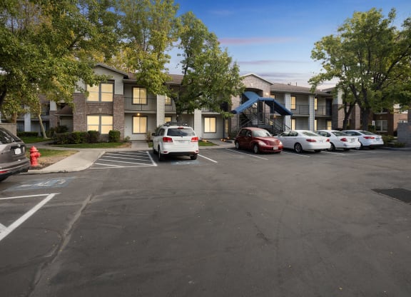 a parking lot with cars in front of an apartment building