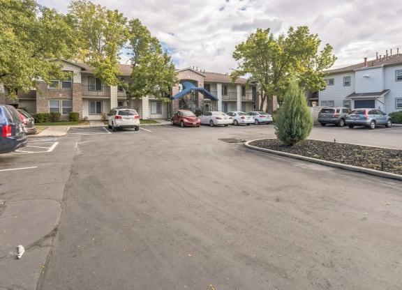 a parking lot with cars in front of apartment buildings