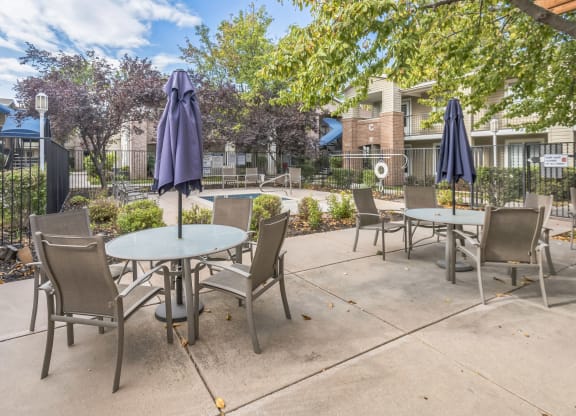 an outdoor patio with tables and chairs and umbrellas