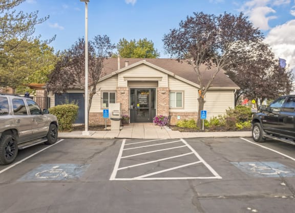 an empty parking lot in front of a tan building with a door