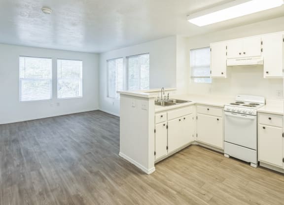 an empty kitchen with white appliances and white cabinets