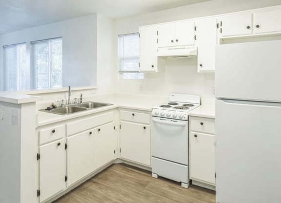 a white kitchen with white appliances and white cabinets