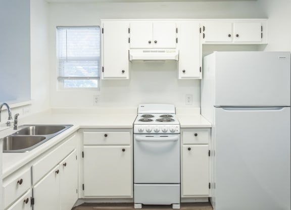 a kitchen with white cabinets and a white stove and refrigerator