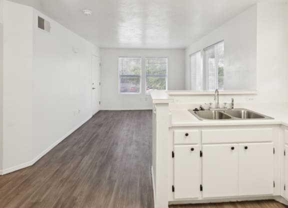 a white kitchen with a sink and white cabinets