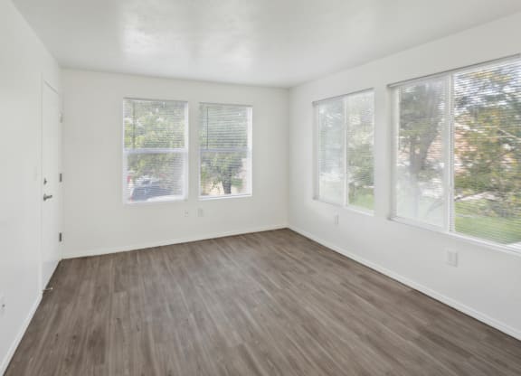 an empty living room with white walls and wood floors