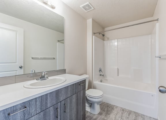 a bathroom with a white tub and sink and a toilet