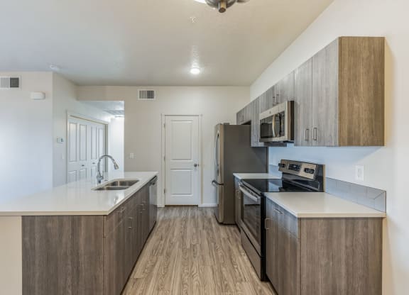 A kitchen with a black fridge and microwave.