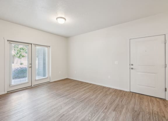 the living room of an empty apartment with a door to the patio