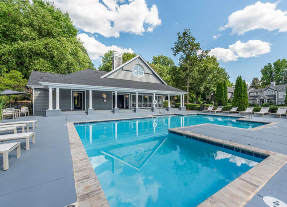 a swimming pool with a house in the background