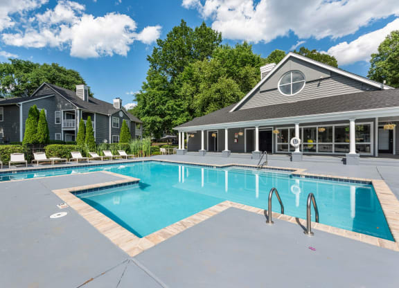 a swimming pool with a house in the background