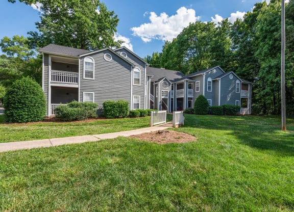 a row of houses with lawns and trees in front of them