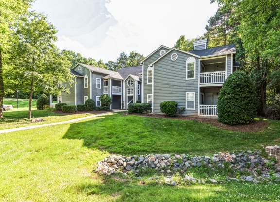 the front yard of a house with a lawn and trees