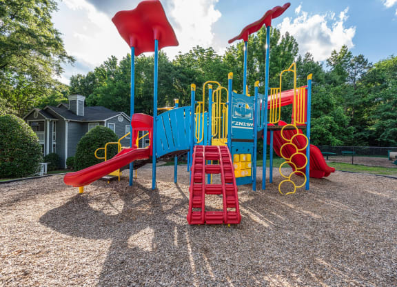 a playground with a swing set and slides at a park