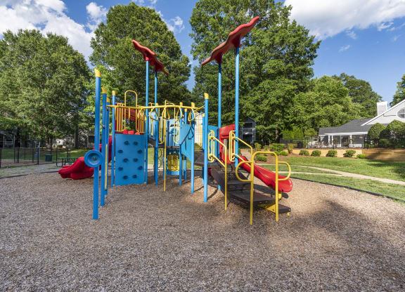 a playground at a park with slides and trees