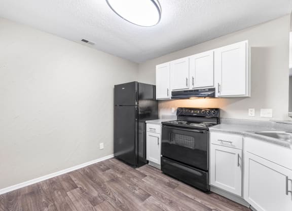 the kitchen of our studio apartment atrium with black appliances and white cabinets