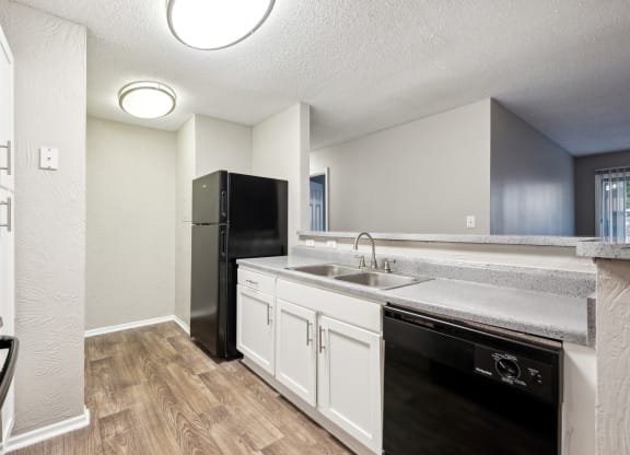 an empty kitchen with a sink and a refrigerator
