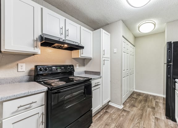 the kitchen of a home with white cabinets and black appliances