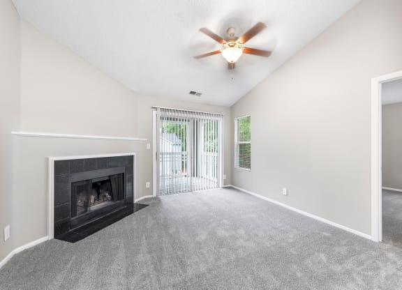 a living room with a fireplace and a ceiling fan
