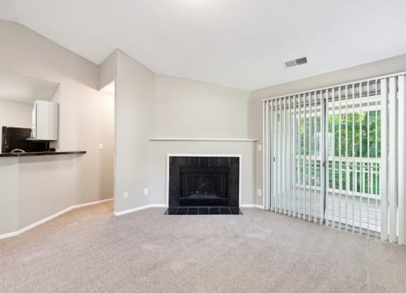 an empty living room with a fireplace and a window