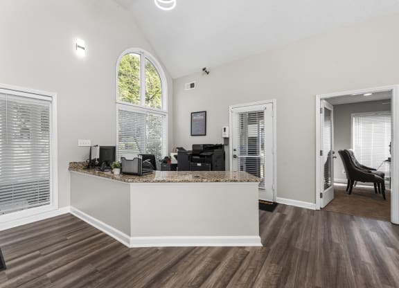 the living room and kitchen of a home with an arched window