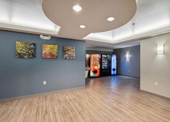 a lobby with blue walls and wood floors and a vending machine