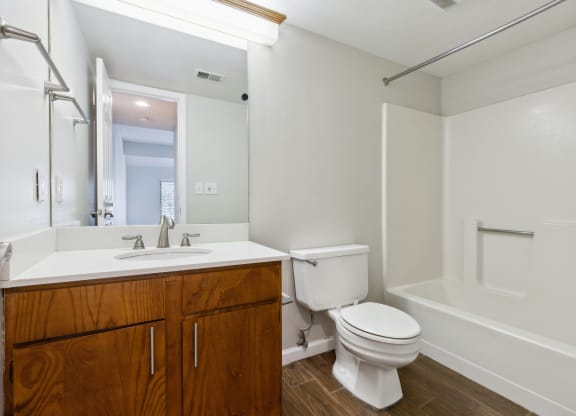 a bathroom with a toilet sink and tub and a mirror