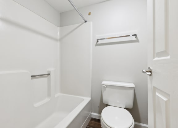 a small bathroom with a toilet and a bath tub