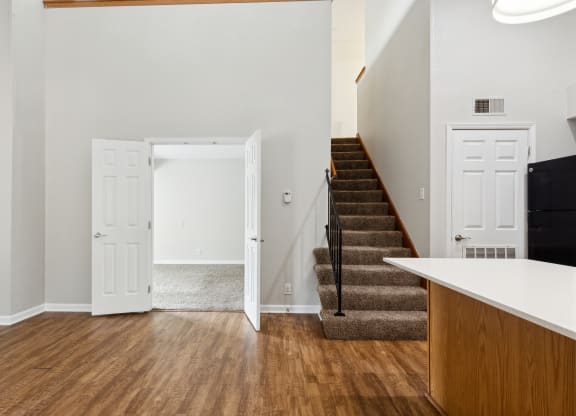 a view of a living room with stairs and a door to a bedroom and a