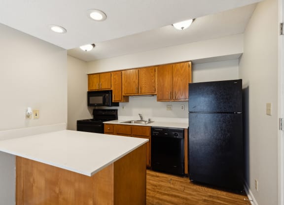 a kitchen with a white counter top and black appliances
