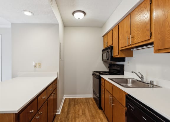 a kitchen with wooden cabinets and a sink and a microwave
