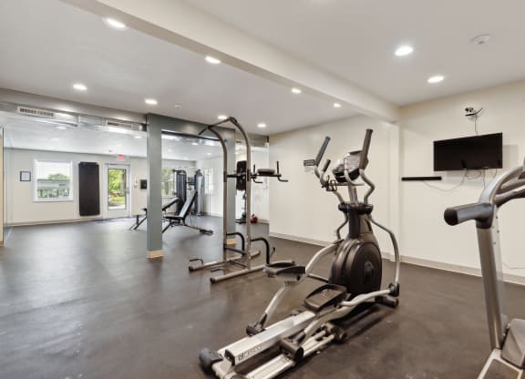a gym with exercise equipment and a tv in a building
