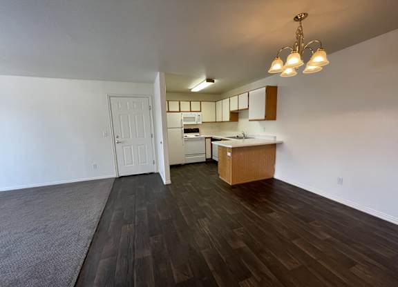 A kitchen with a white door and a brown counter.