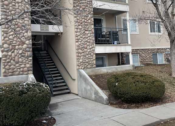 A stone building with a black railing and steps.