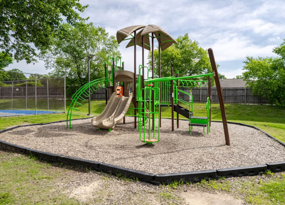 a playground with a swing set and slides in a park