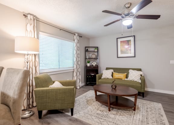 a living room with couches and a table and a ceiling fan