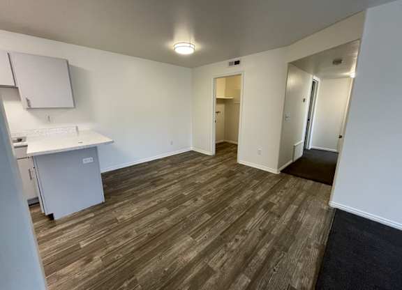 A room with a white counter and a white fridge.