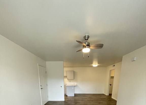 A room with a ceiling fan and carpeted floor.