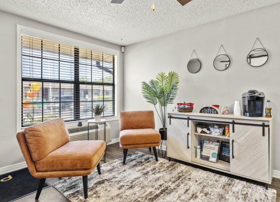 a living room with two chairs and a table and a window