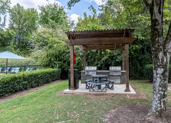 a picnic pavilion with a table and chairs in a park
