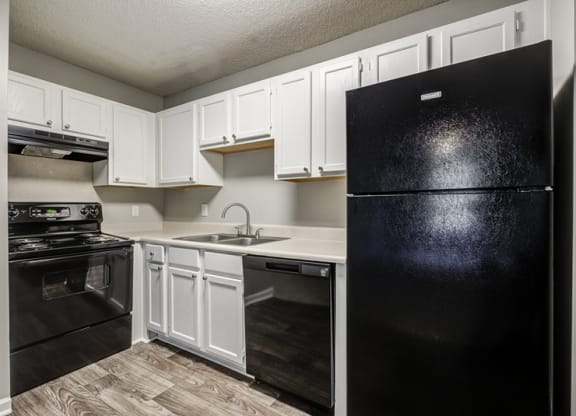 a kitchen with black appliances and white cabinets