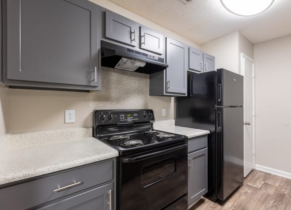 a kitchen with black appliances and white counter tops and a black refrigerator