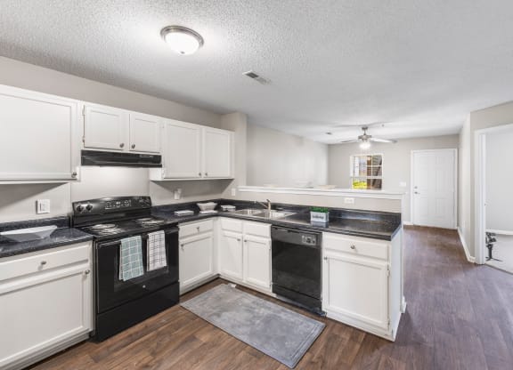 a kitchen with white cabinets and black appliances