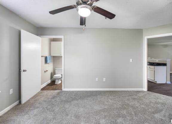 an empty living room with a ceiling fan