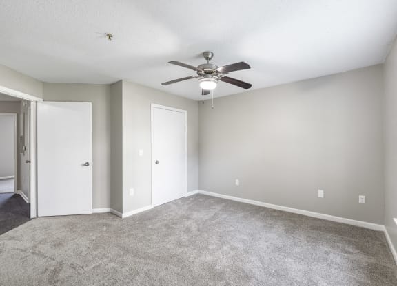 an empty living room with a ceiling fan