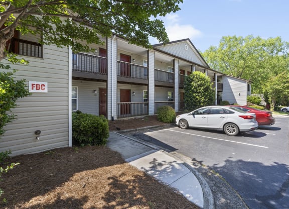 an apartment building with a parking lot and cars parked in front