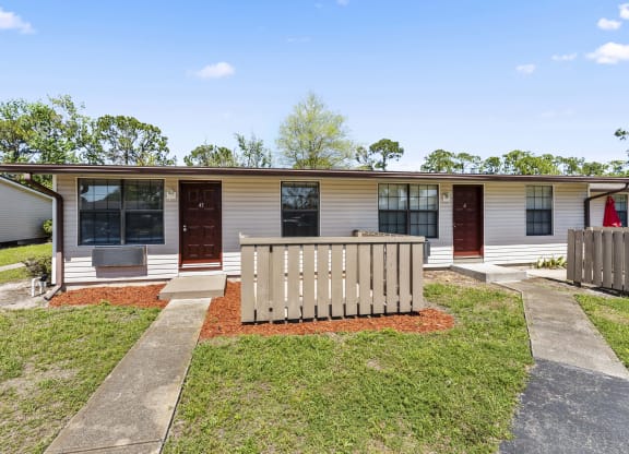 a white mobile home with a white fence in front of it